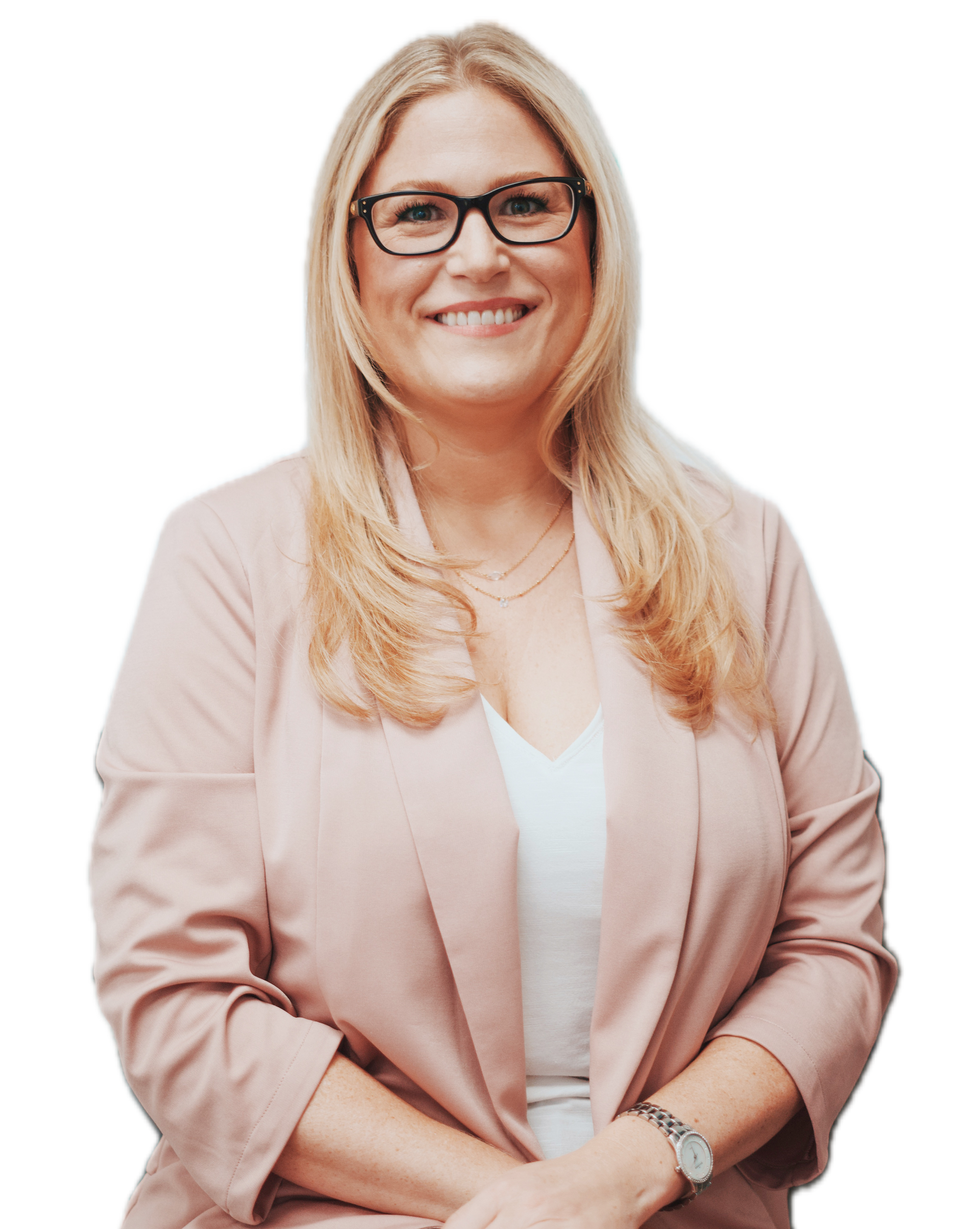 A woman wearing glasses and a pink jacket is smiling.