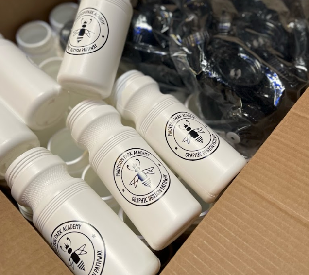 A box of white plastic bottles with bees on them