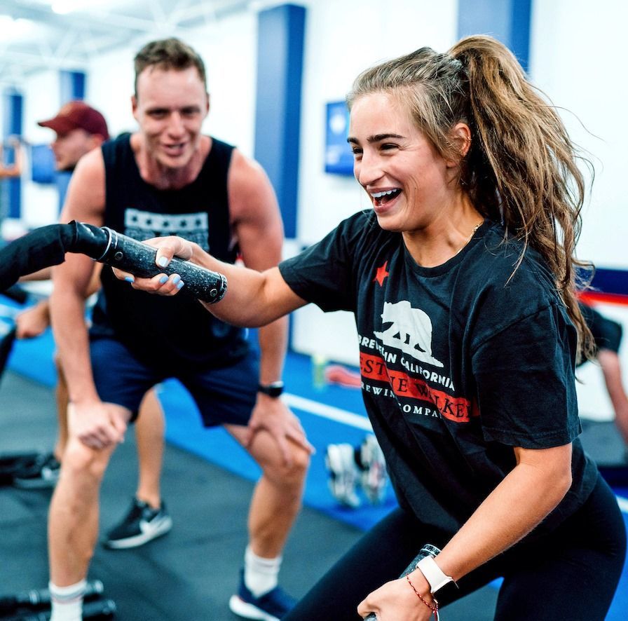 People smiling and doing a tug-of-war exercise in a gym