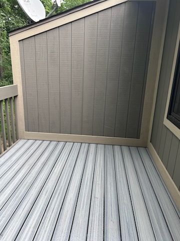 Deck with gray and brown composite material, satellite dish, and wood trim.