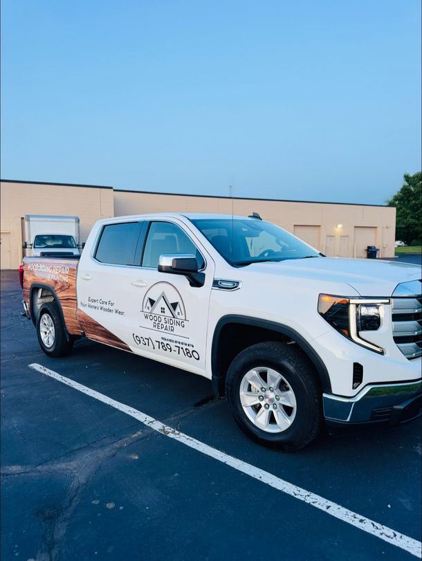 White truck with company logo parked in a lot. Copper accents on the bed.