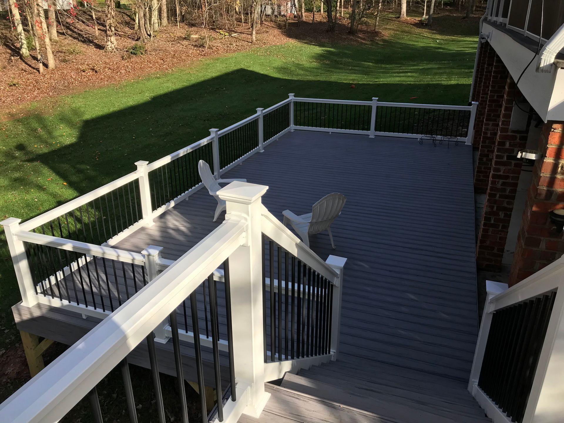 A deck with a white railing and stairs leading up to it