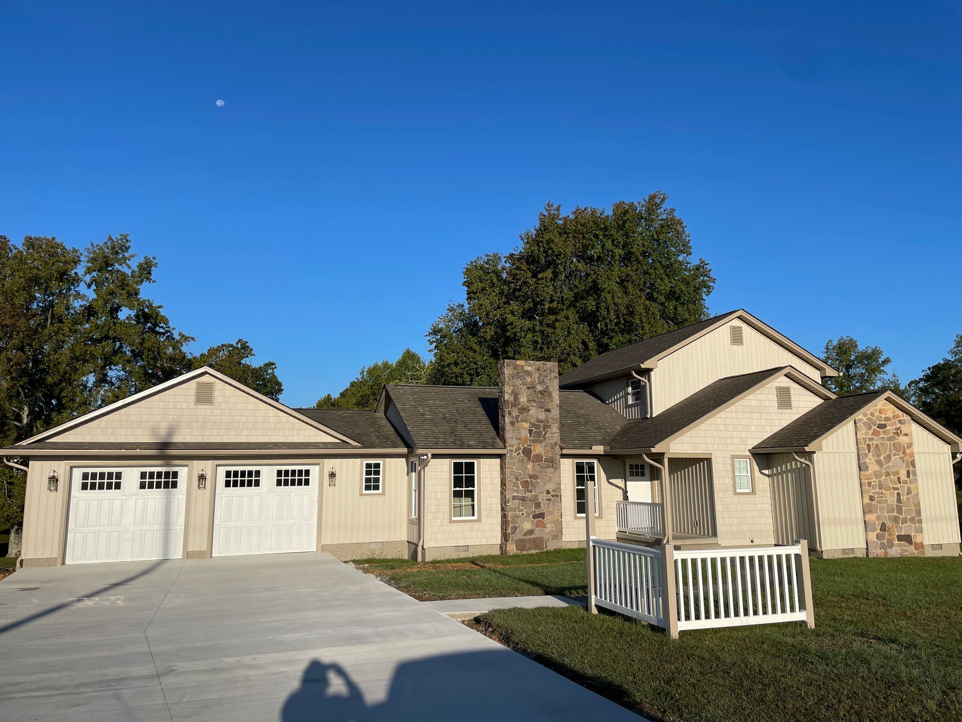 A large house with two garages and a fence in front of it