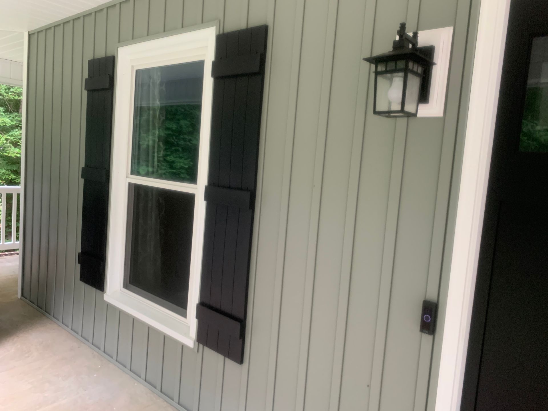 A house with a window and black shutters on it.