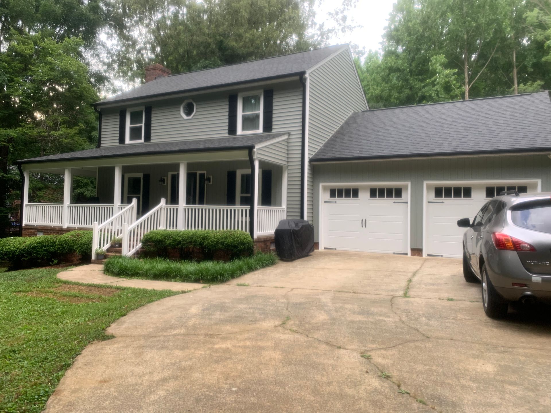 A large house with a car parked in front of it.