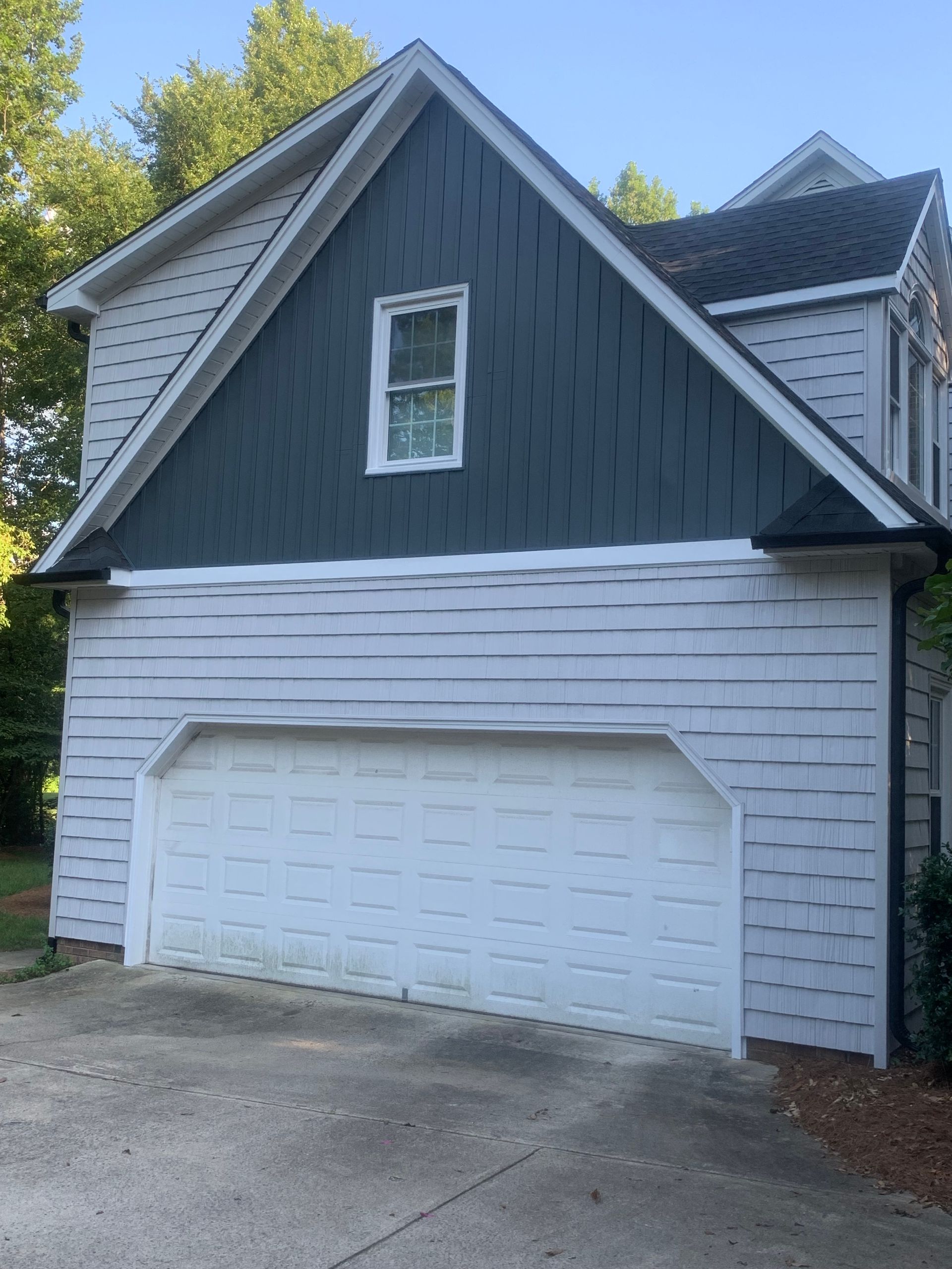A house with a white garage door and a black roof