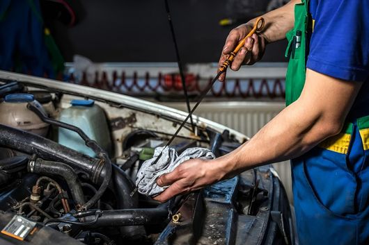Mechanic in Mount Isa Inspects the dip stick for oil levels