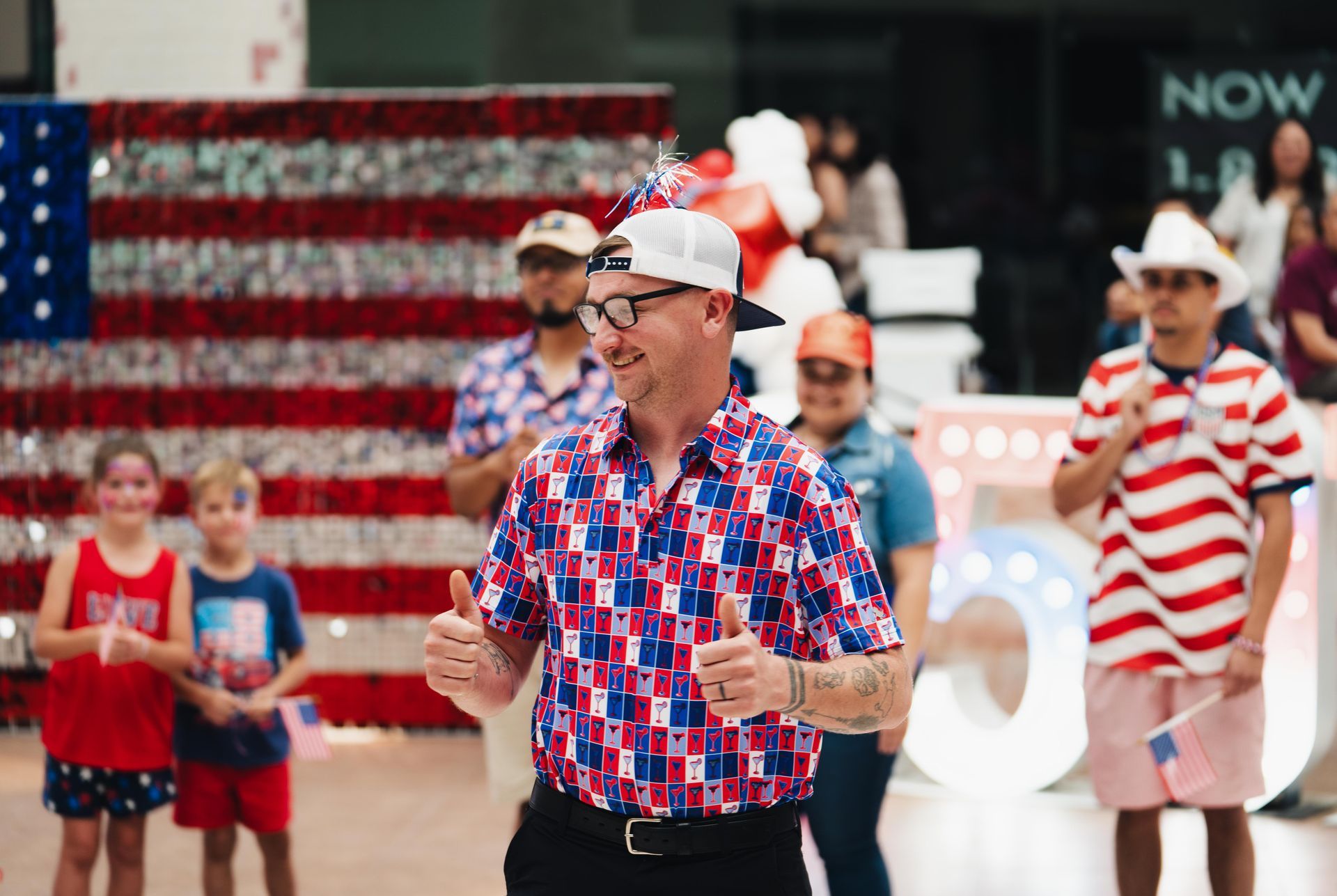 People in patriotic red, white, and blue outfits walking in a festive outdoor event
