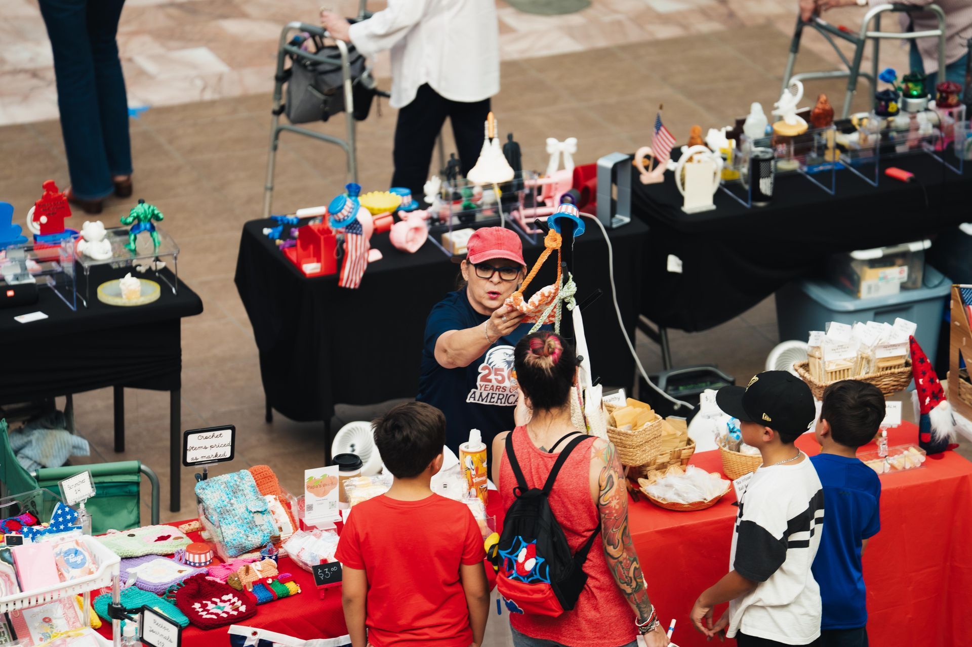 Toy stall at a market, with colorful figurines and a vendor serving customers.