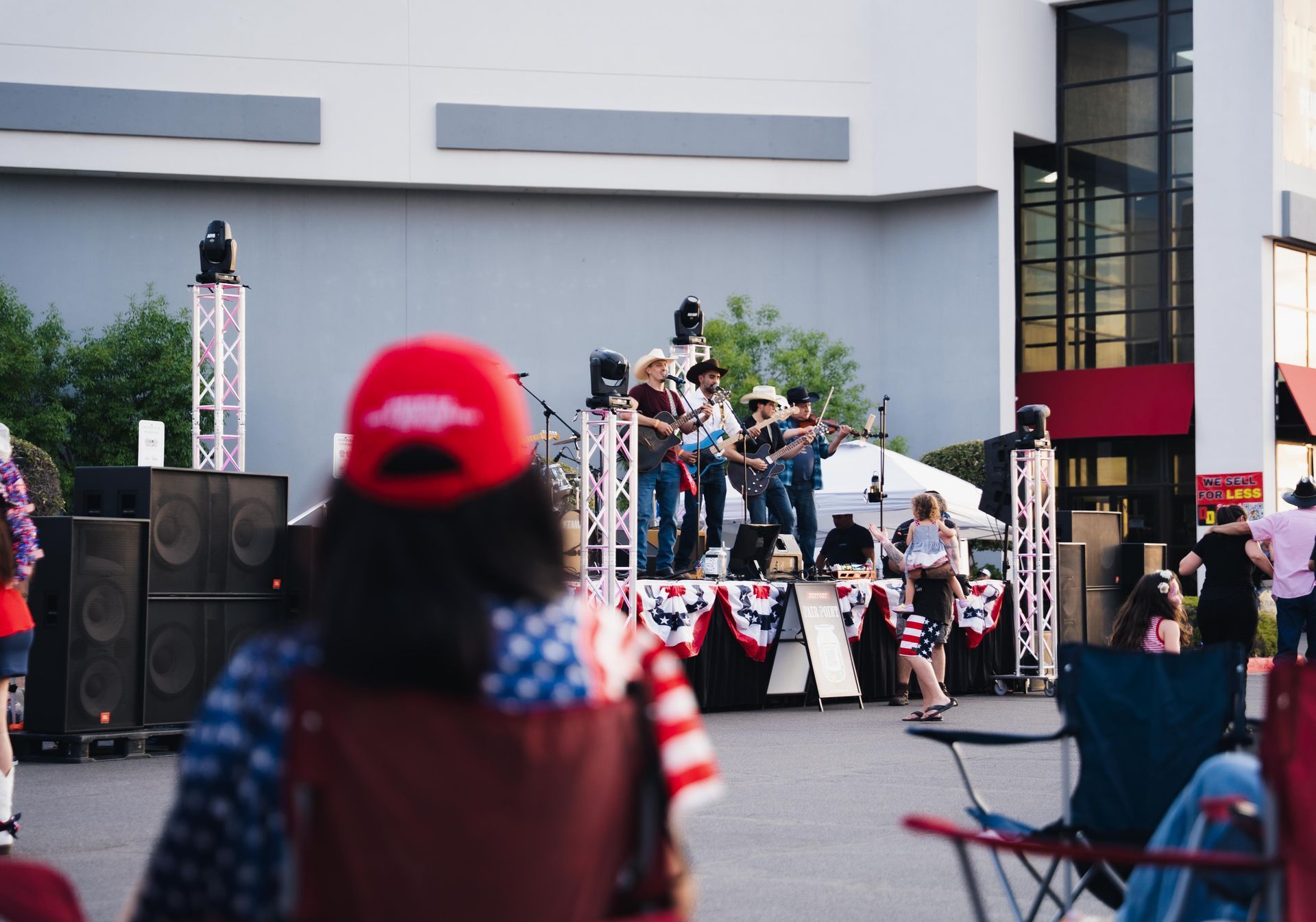 Crowd watching a colorful outdoor stage performance in front of a building