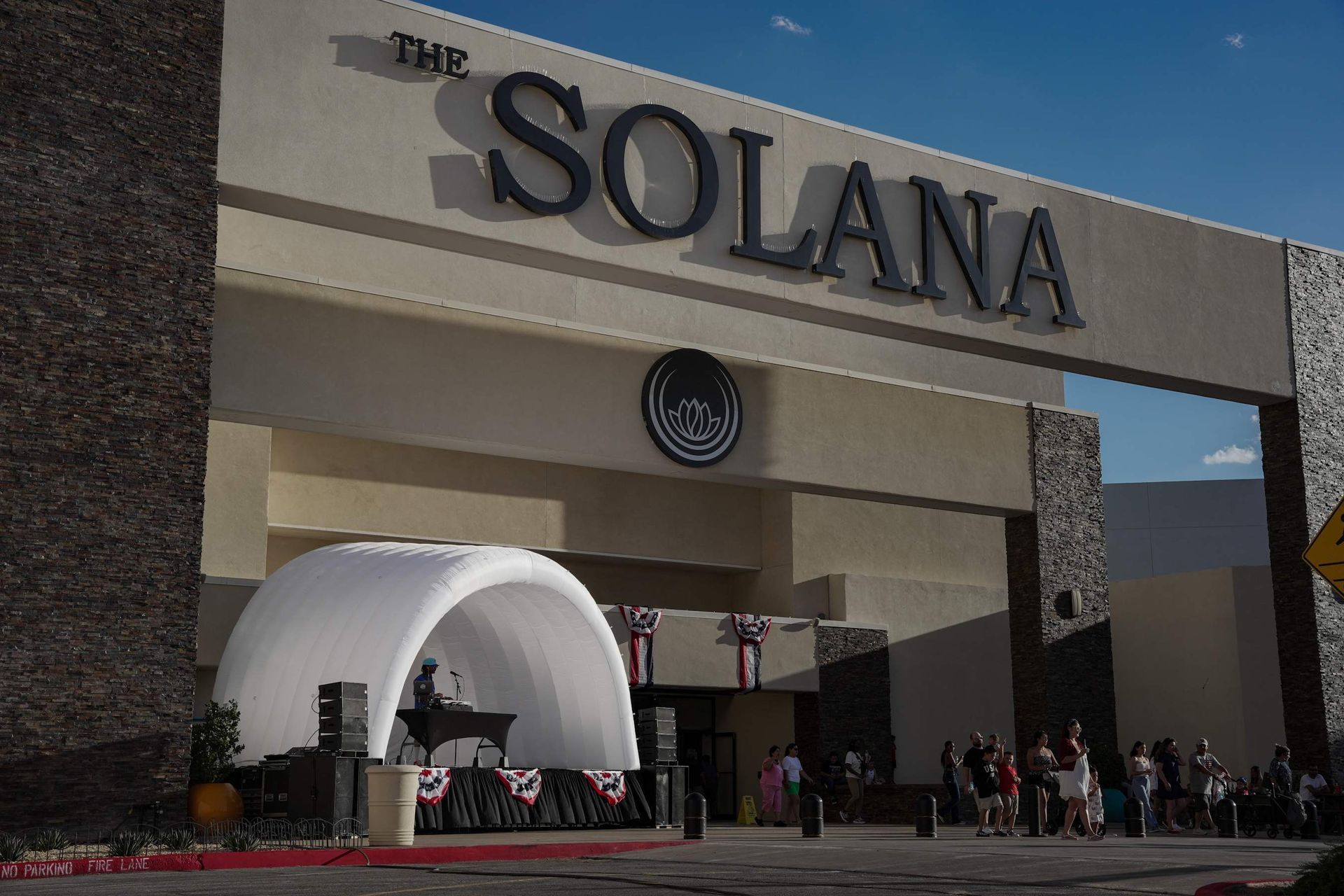 The Solana shopping center entrance with a white canopy and people gathered outside.