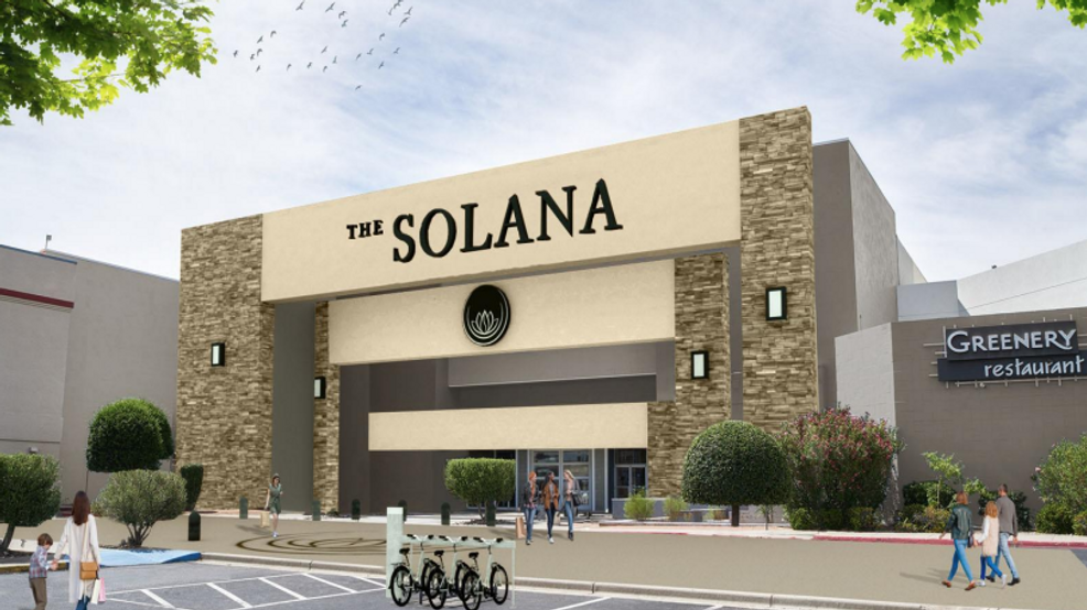 Entrance of The Solana shopping center with tan stone facade and Greenbery sign, pedestrians nearby