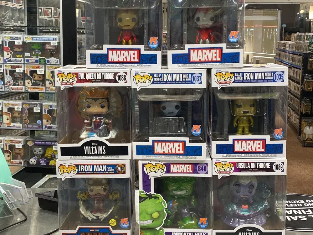 A bunch of marvel funko pop figures are stacked on top of each other in a store.