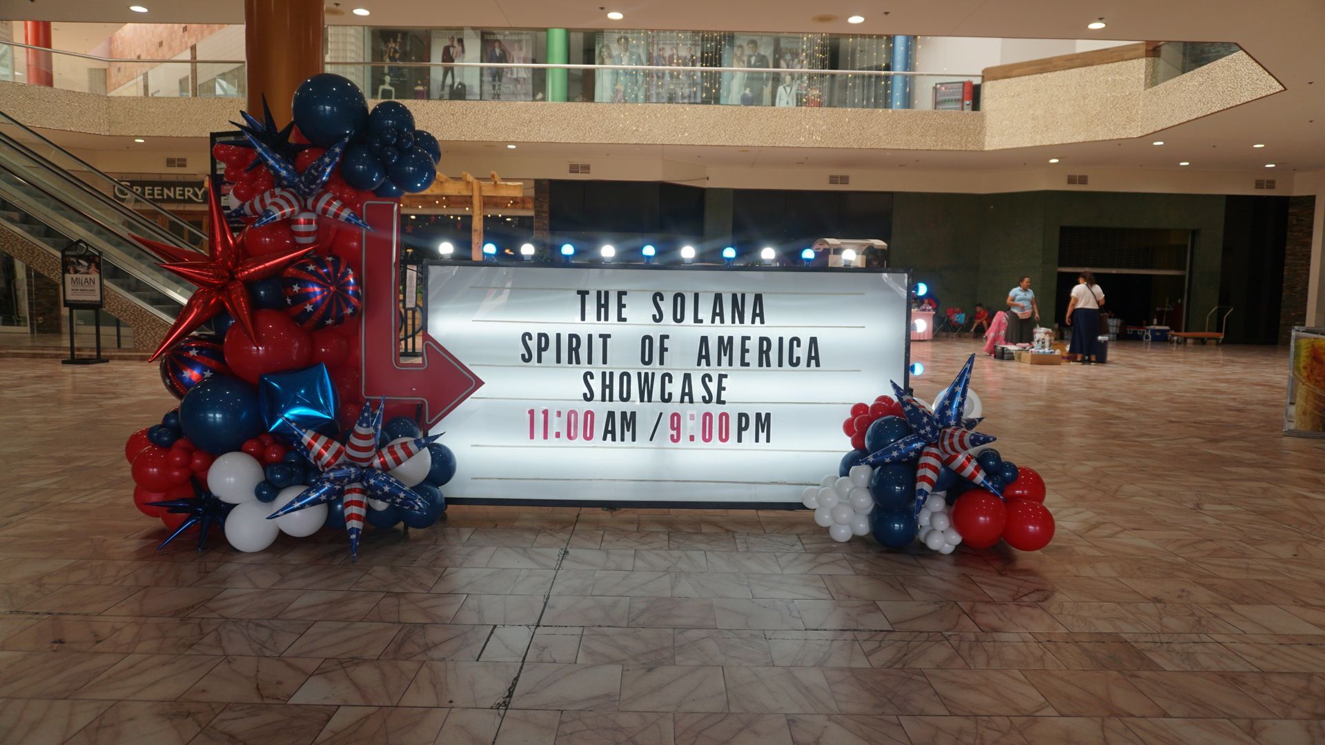Mall marquee for “The Sabrina Show: A Holiday Spectacular,” framed by red, white, and blue balloon decorations.