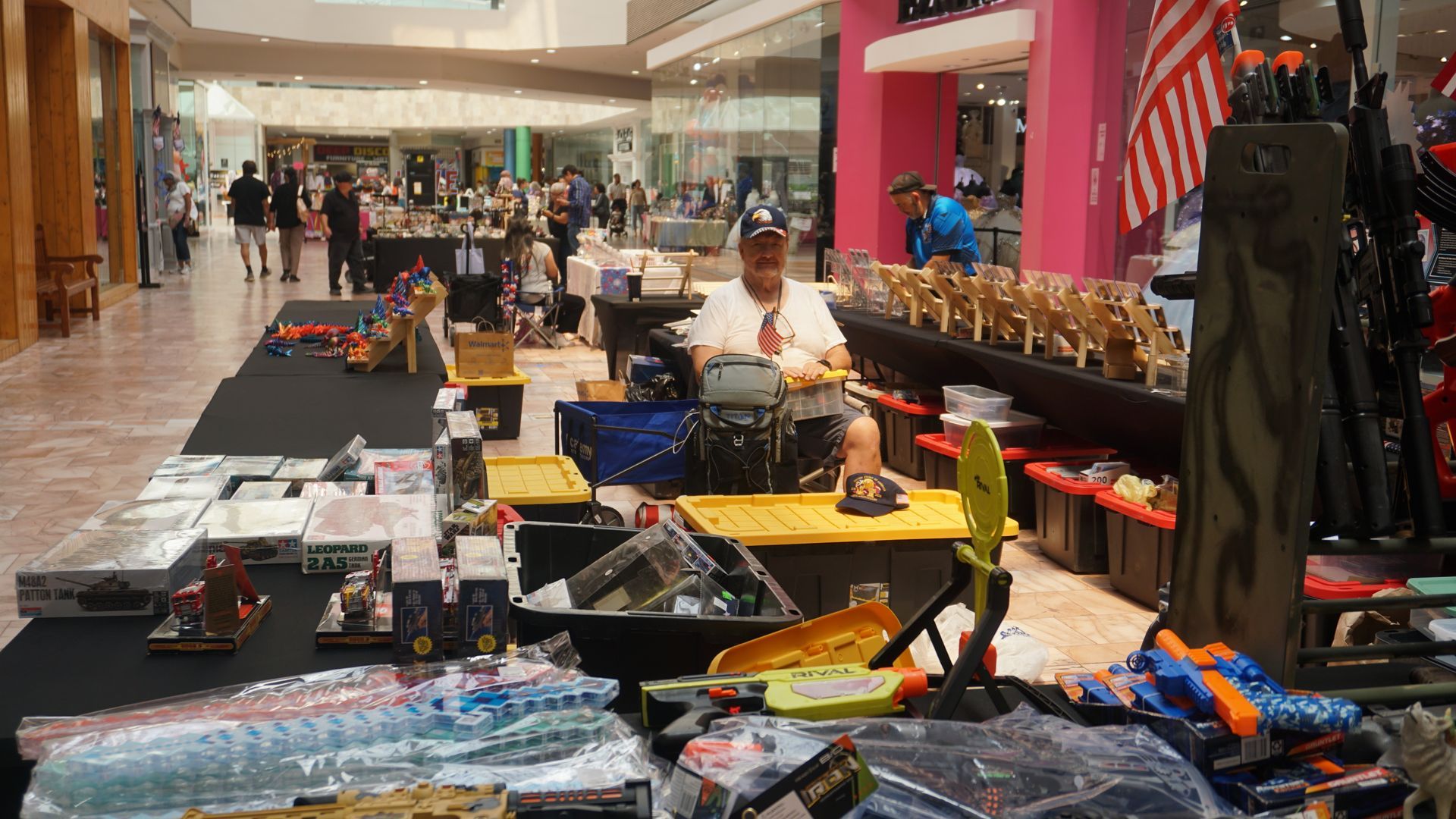 Mall kiosk with display tables of assorted merchandise in a shopping mall corridor