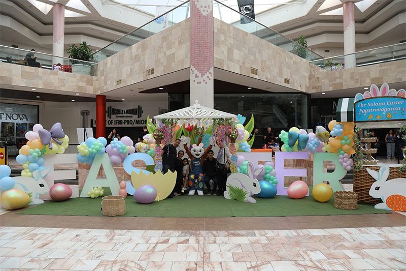 Easter mall display with pastel balloons, giant letters, and a decorated photo backdrop