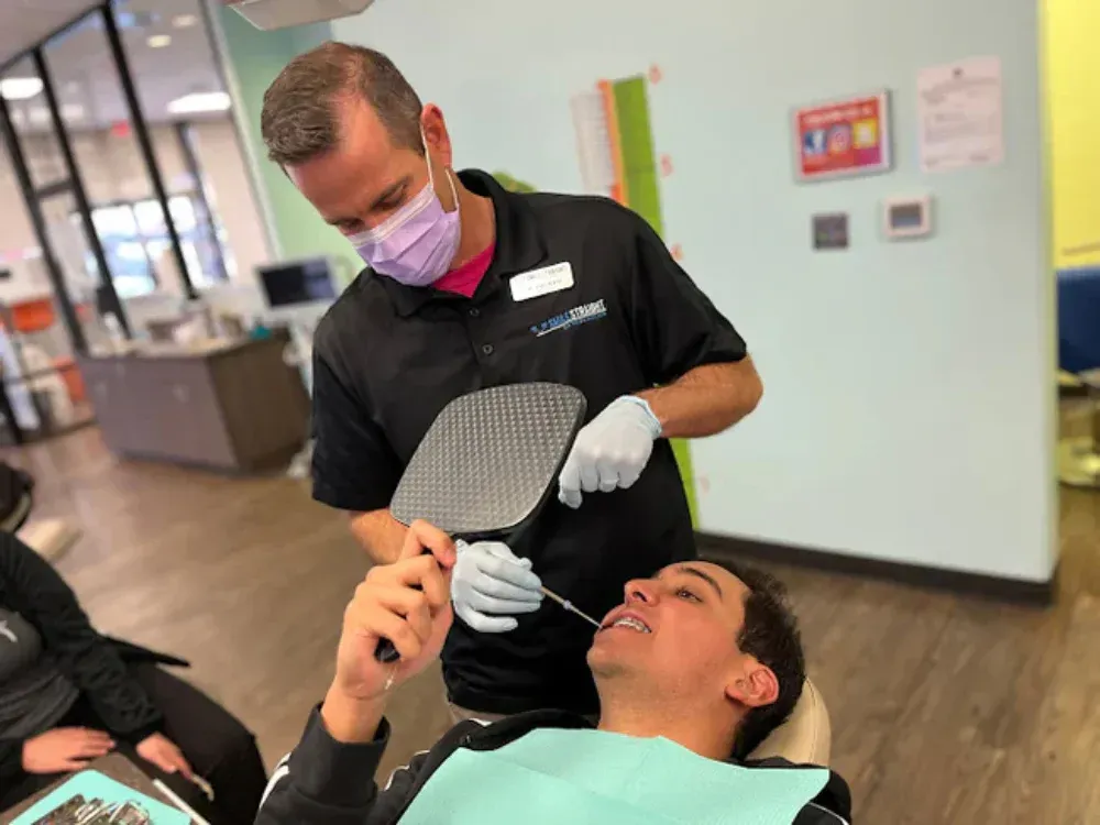 A dentist is examining a patient 's teeth in a dental office.