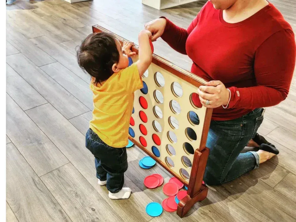 A woman and a child are playing a game of connect four.