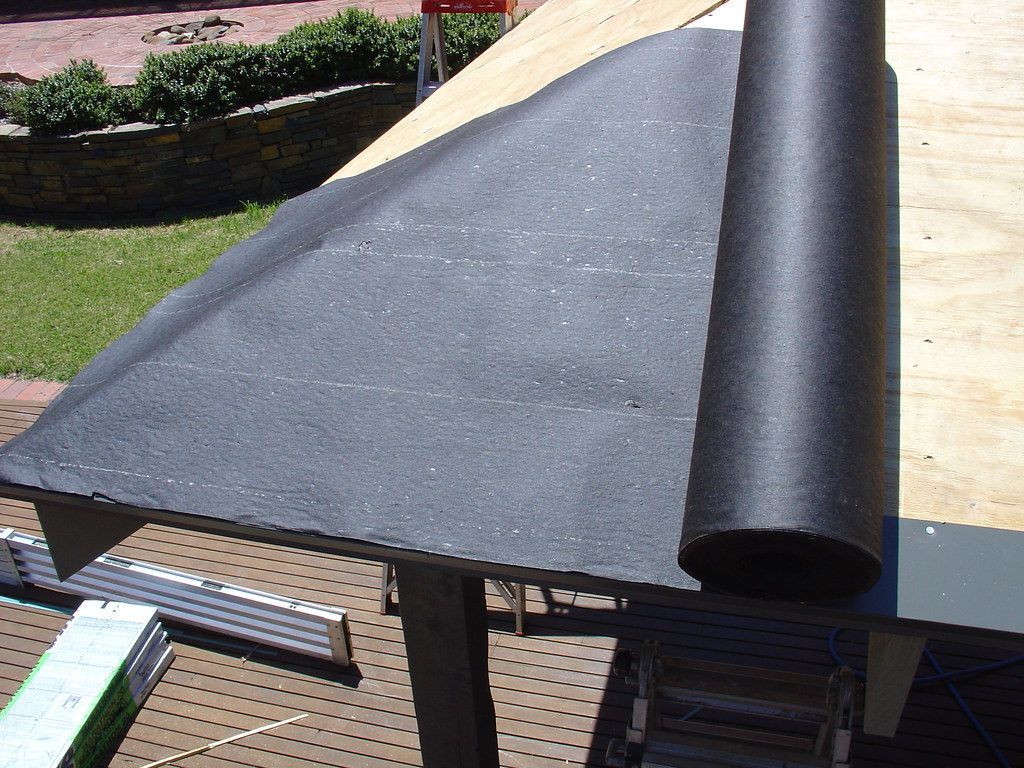 A roll of asphalt saturated felt is sitting on top of the roof