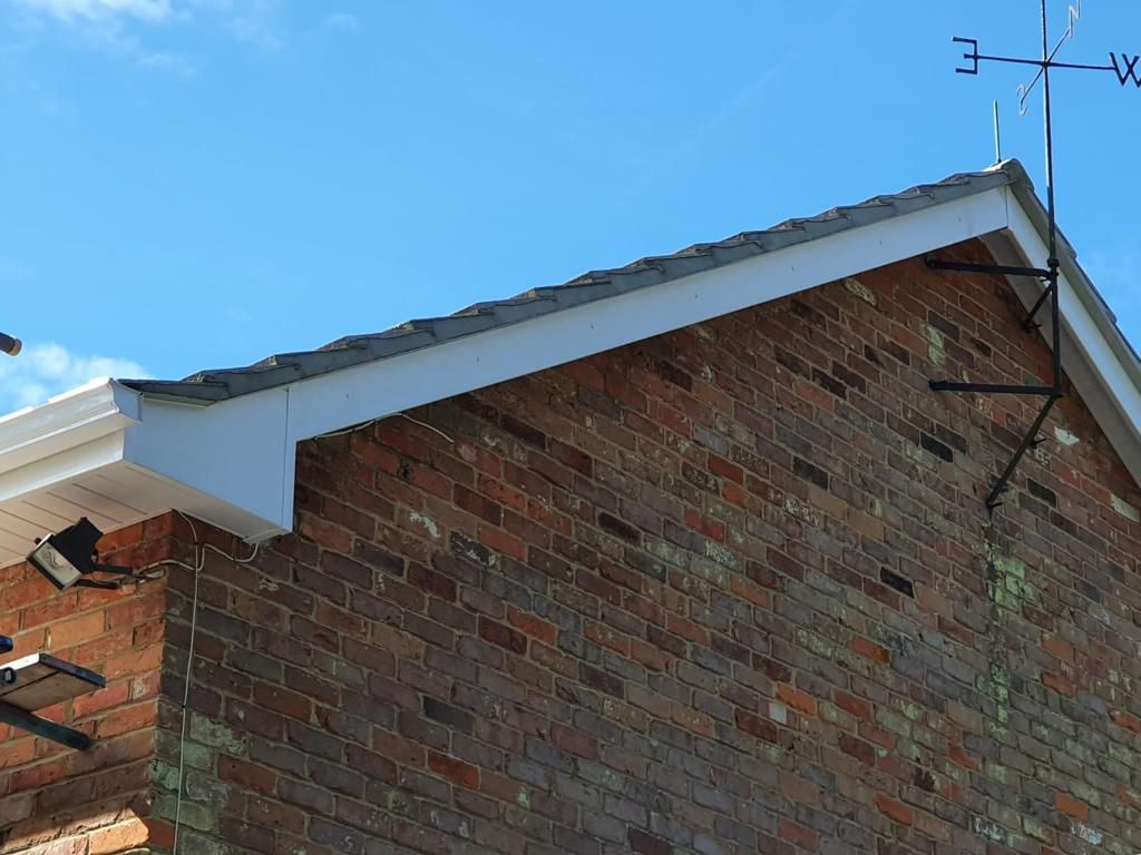 a weather vane on top of a brick building with the letter e on it