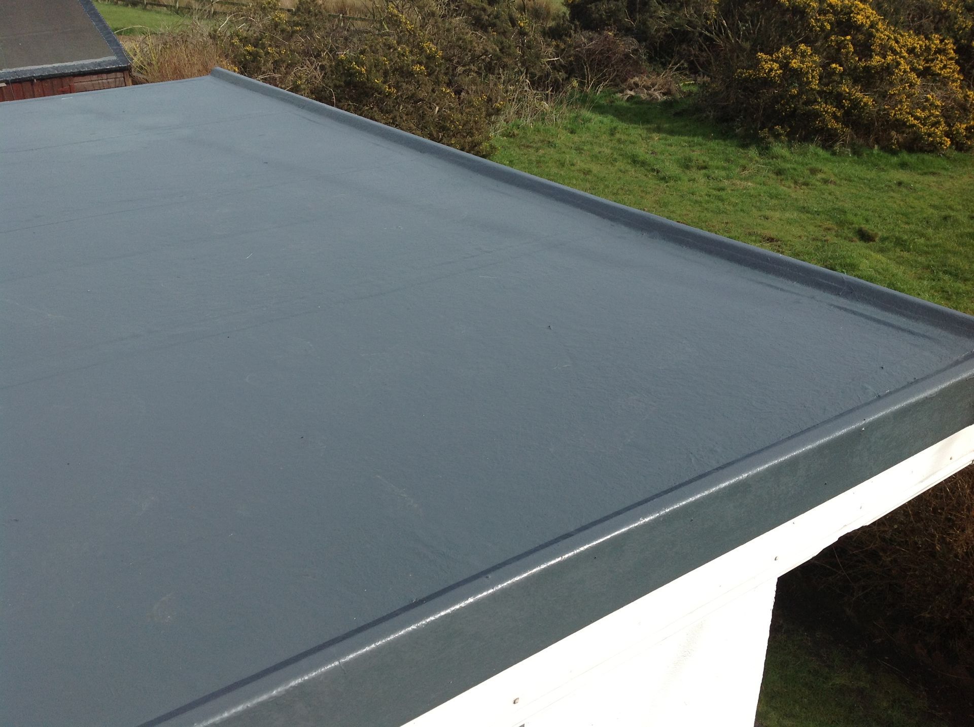 A black roof is sitting on top of a white building.