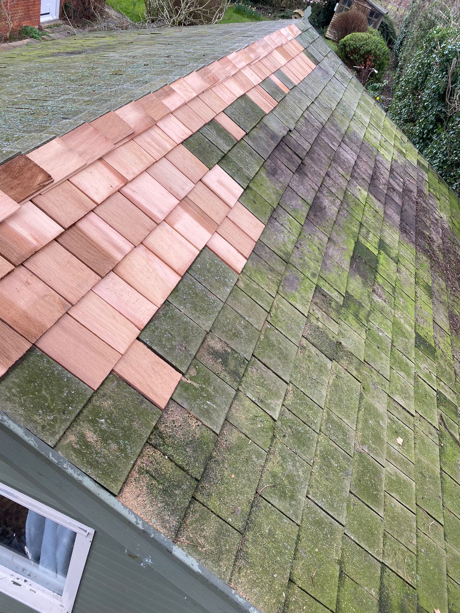 a roof with wooden tiles and moss on it