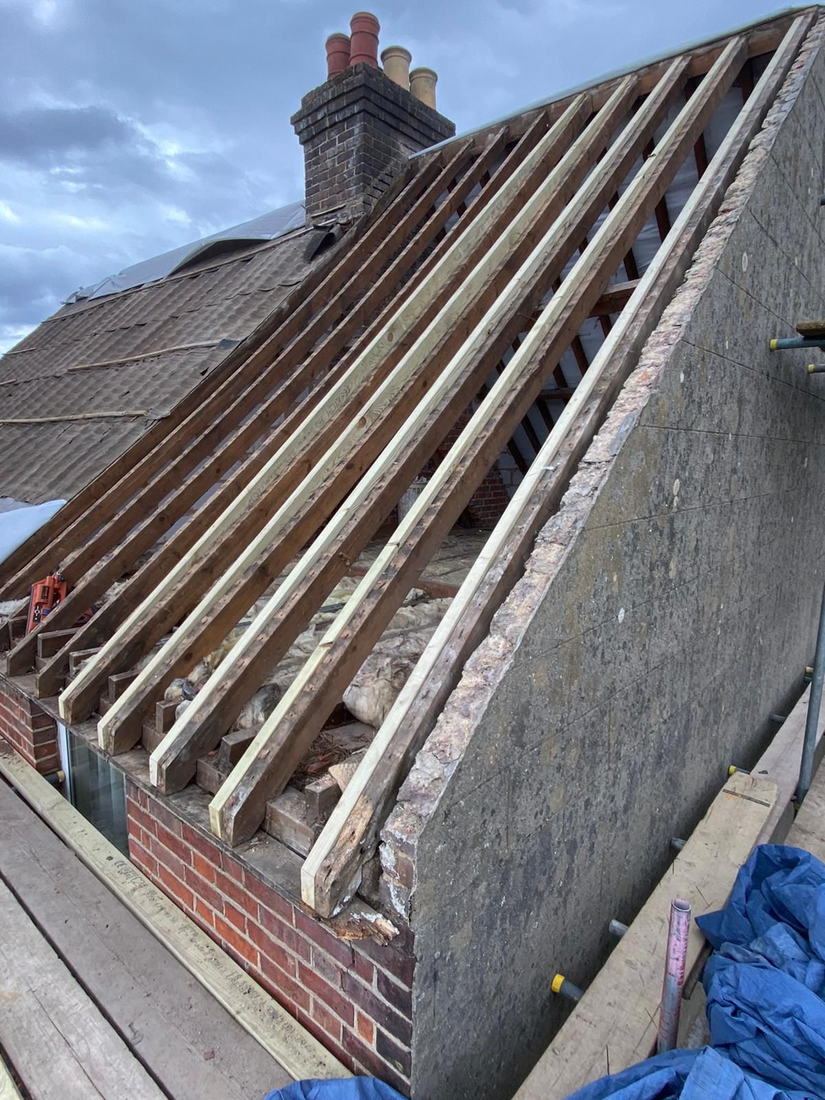 a wooden roof is being built on a brick building