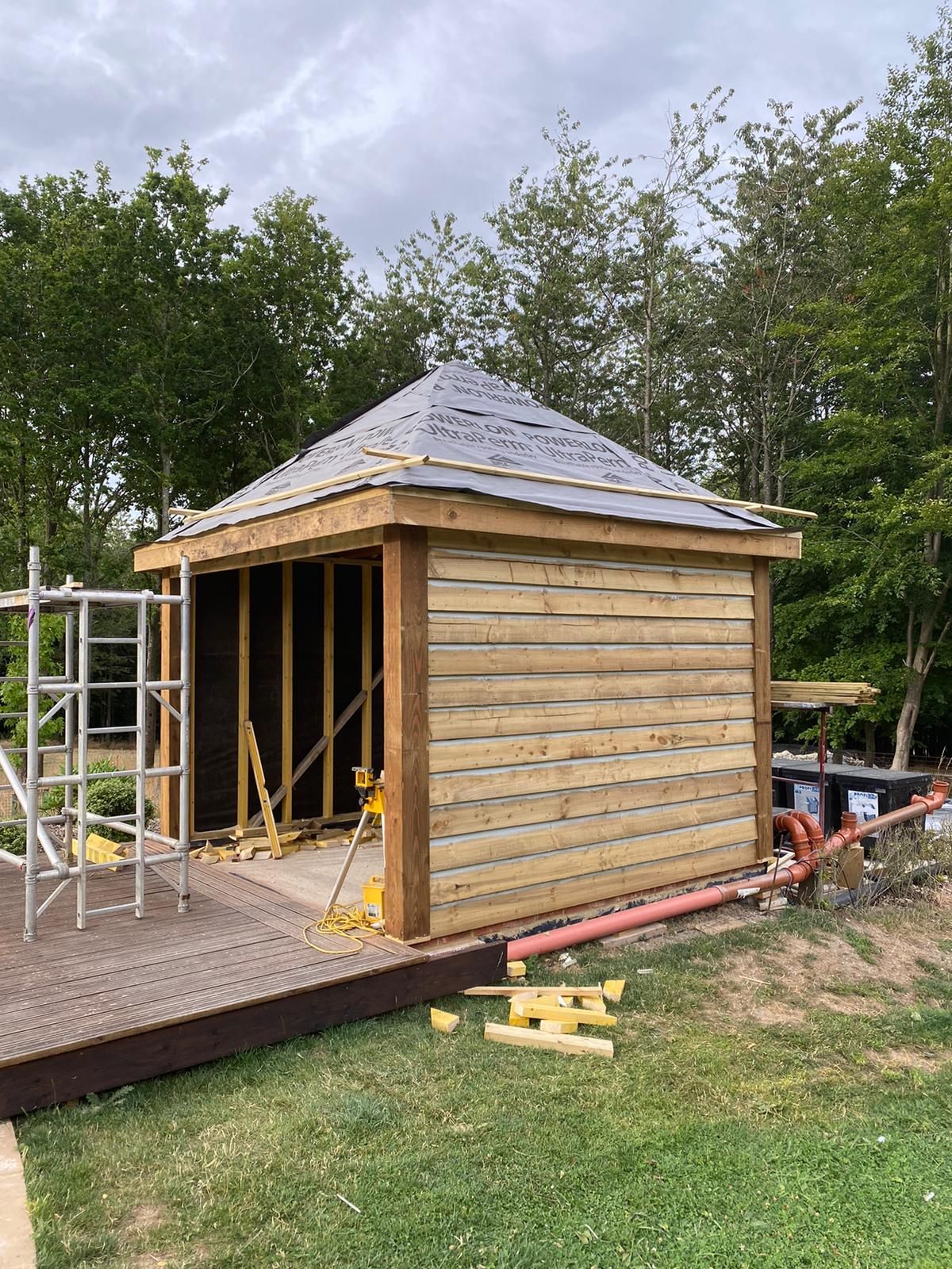 a wooden shed is being built and the roof is covered with a tarp