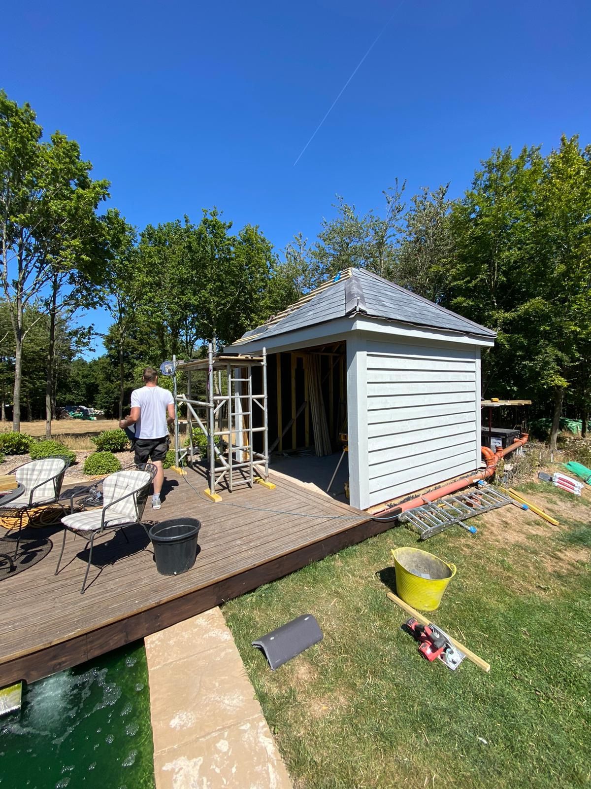 a man standing on a deck next to a building under construction