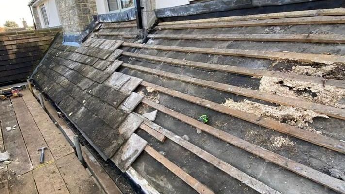 A roof with a lot of shingles on it is being repaired.