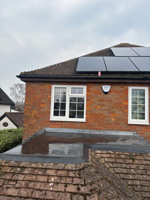A brick house with chimney on the roof.