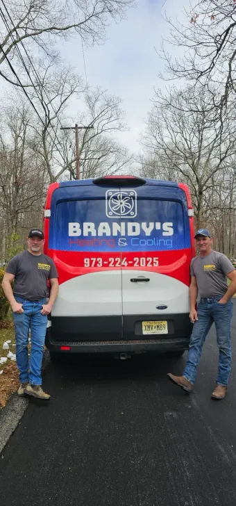 Two men stand by a branded van. The van has the business name