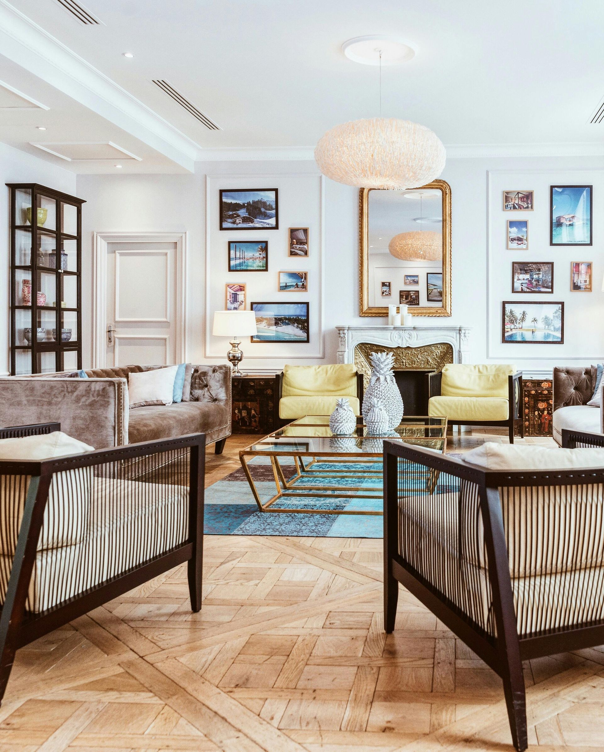 Elegant living room with light-colored walls, wood floors, and mixed seating arrangements.