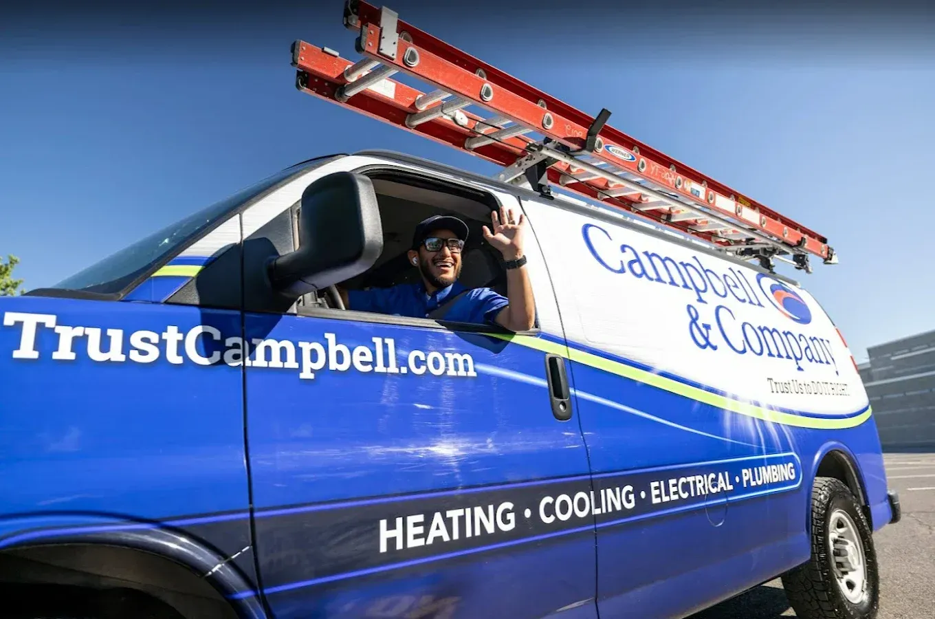 Blue service van with ladder; driver waves.