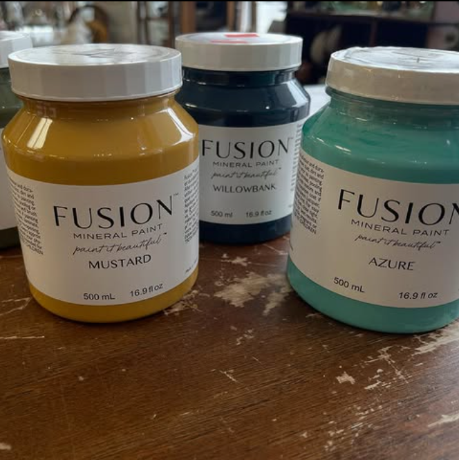 Three jars of Fusion mineral paint: Mustard, Willowbank (dark blue), and Azure (teal).