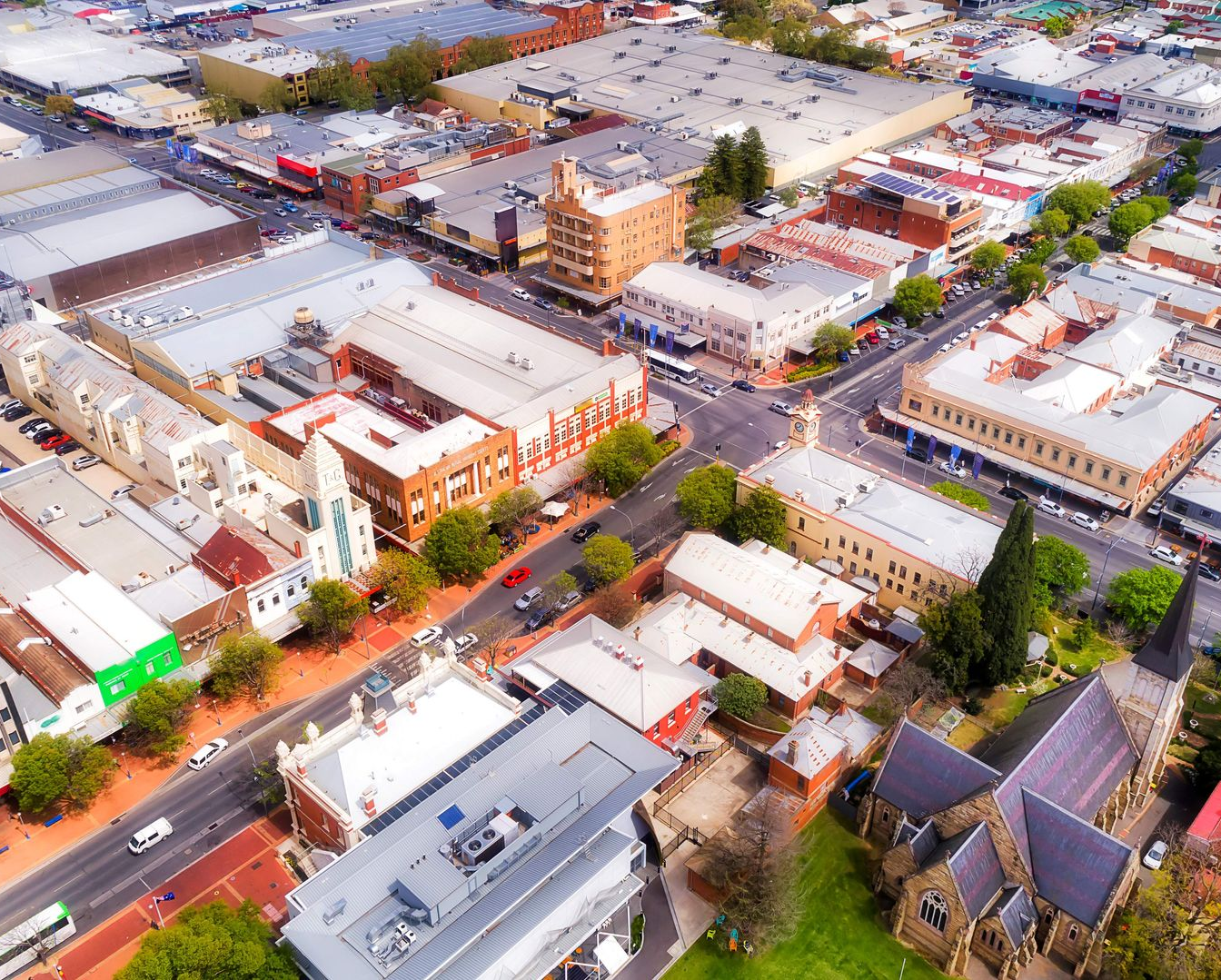 Aerial view of a small town with streets, buildings, and trees under daylight.