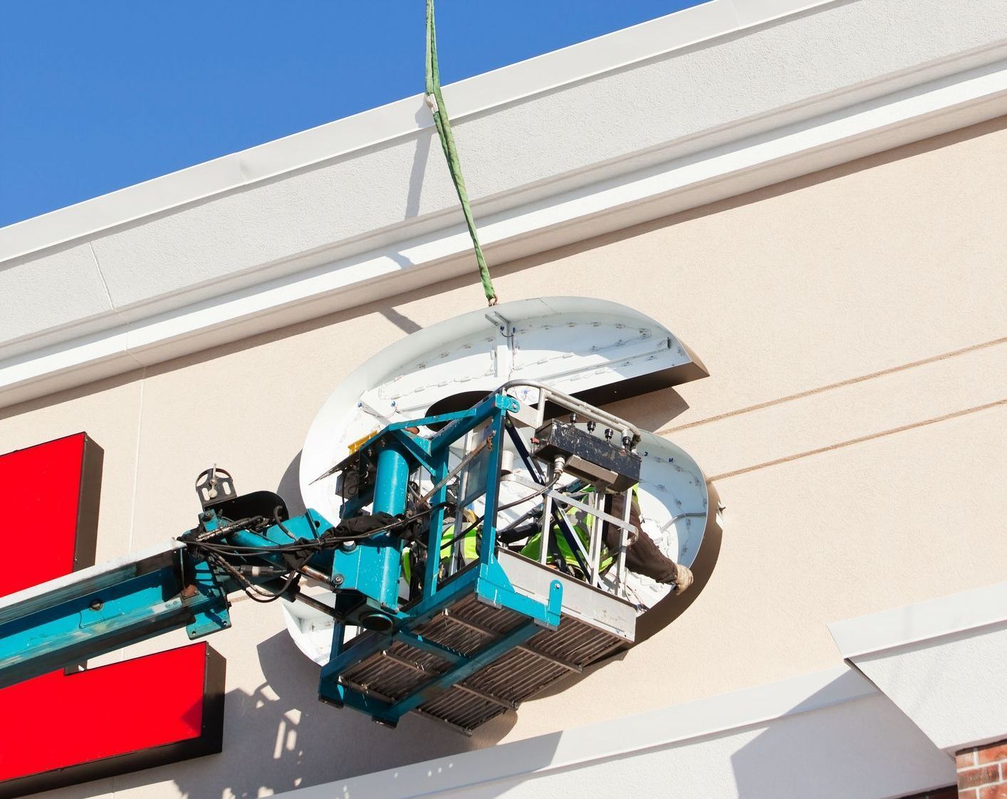 A man is painting a billboard with a brush.