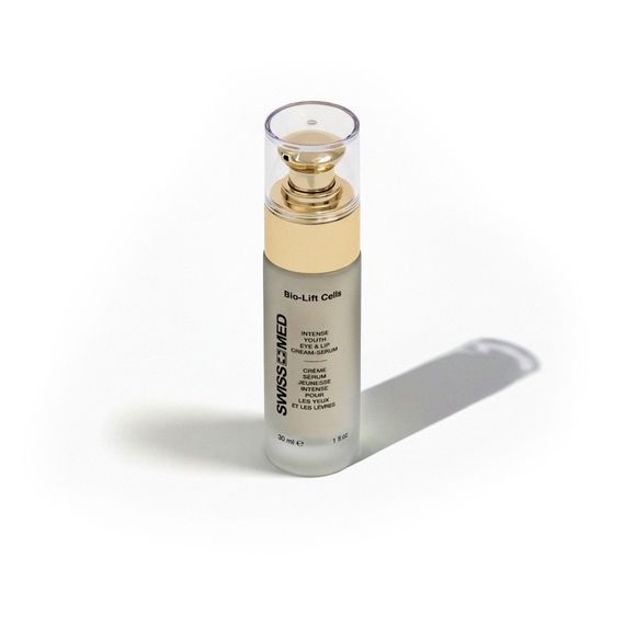Eye cream bottle with gold accents, cap on, casting a shadow.