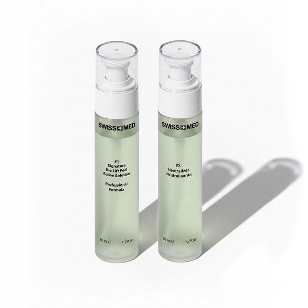 Two clear bottles of Swissmed3 skin care products, with white pumps, on a white surface.