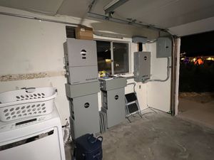 Garage with stacked gray utility boxes, a laundry basket, and an open doorway at night