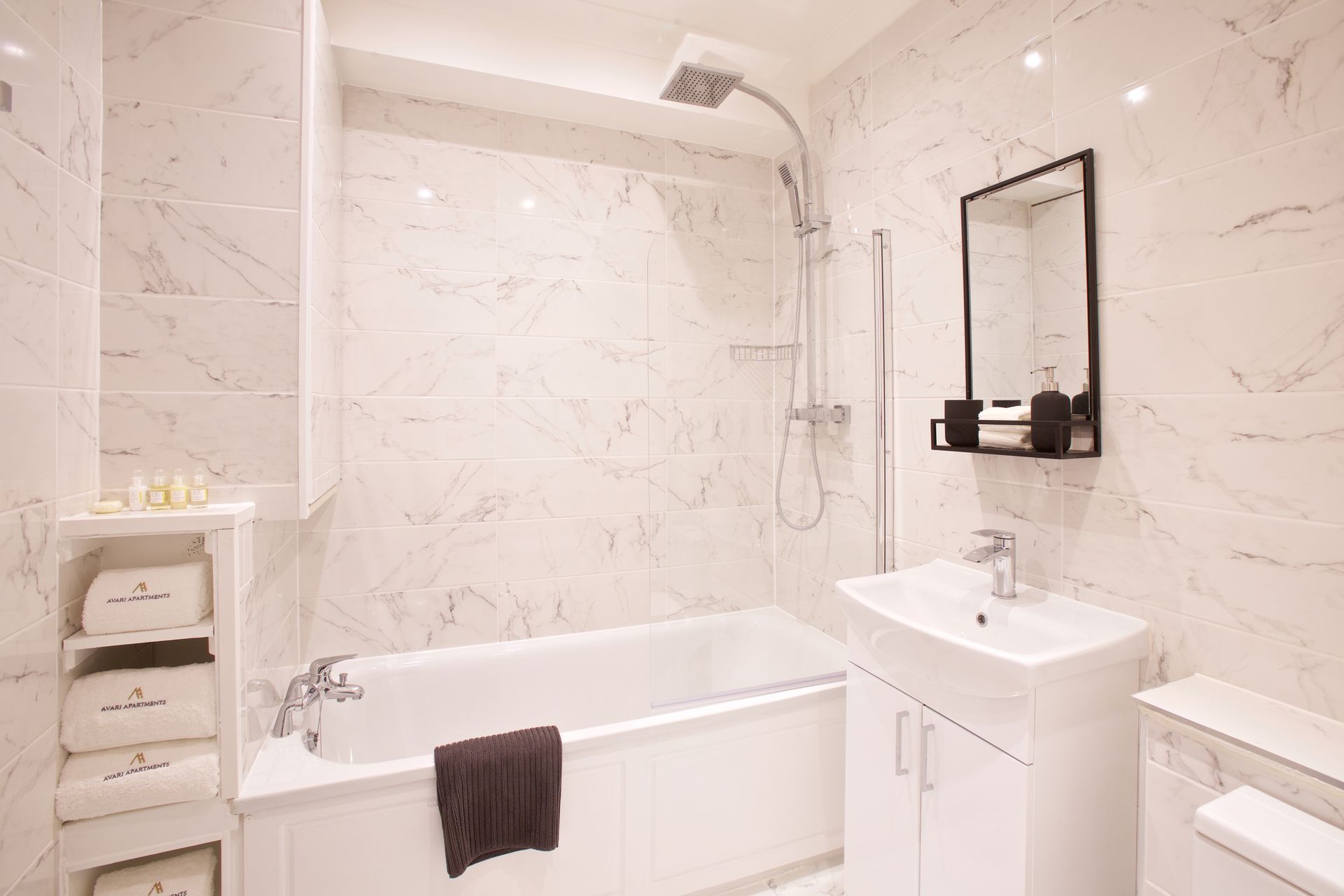 Bright white bathroom with bathtub, sink, shower, and towel rack