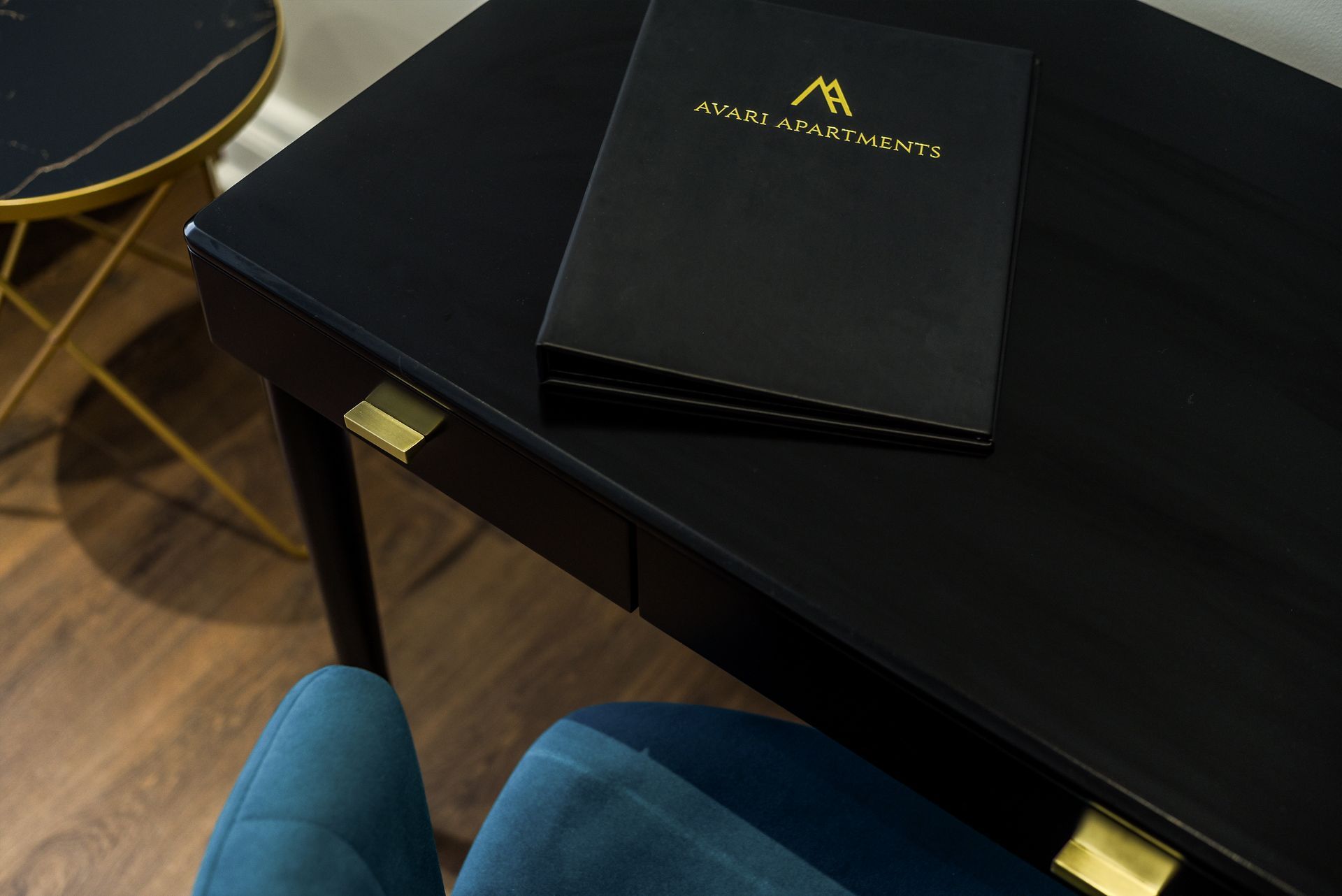 Black table with a branded menu or brochure on top, viewed from above in a modern restaurant setting