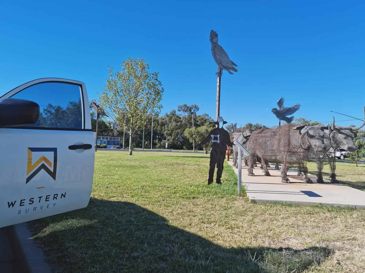 A Man Is Standing Next To A Truck In A Park — Western Survey Pty Ltd In Mudgee, NSW