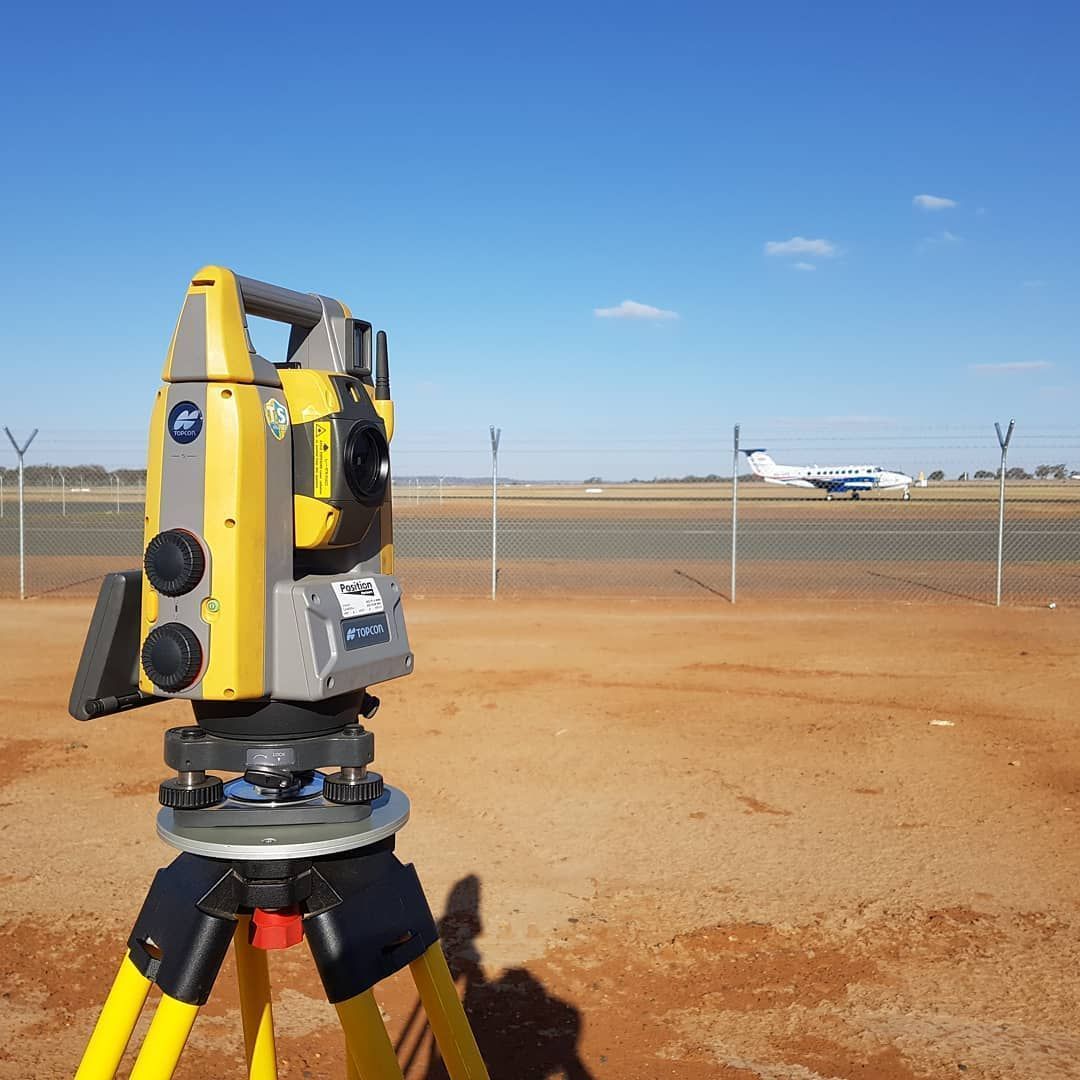 A Yellow And Gray Theodolite Is On A Tripod In A Field — Western Survey Pty Ltd In Dubbo, NSW