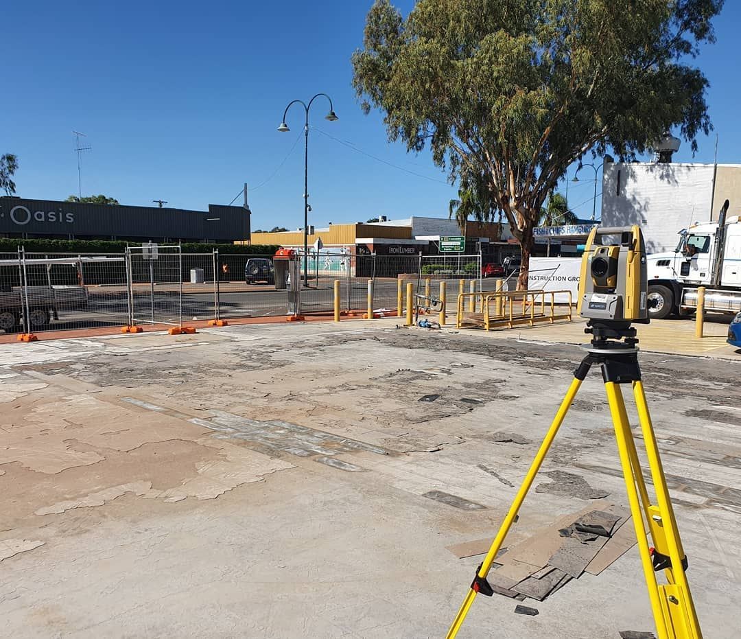 A Yellow Tripod Is Sitting On A Dirt Road In Front Of A Building — Western Survey Pty Ltd In Dubbo, NSW