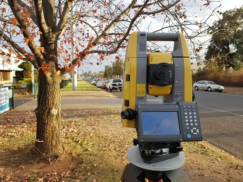 A Total Station Is Sitting In Front Of A Tree On The Side Of The Road — Western Survey Pty Ltd In Dubbo, NSW