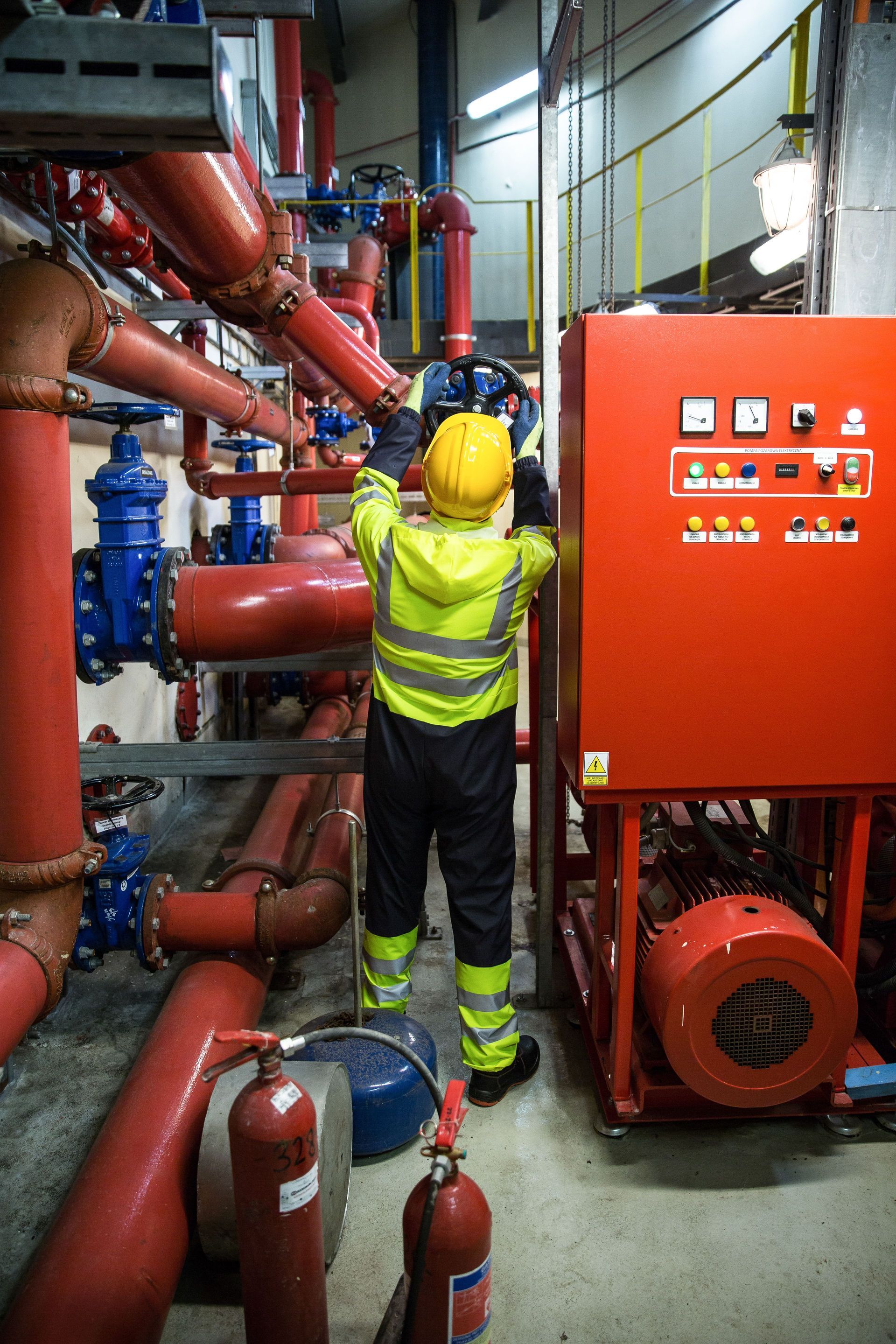 Technician performing annual fire extinguisher inspection and compliance tagging