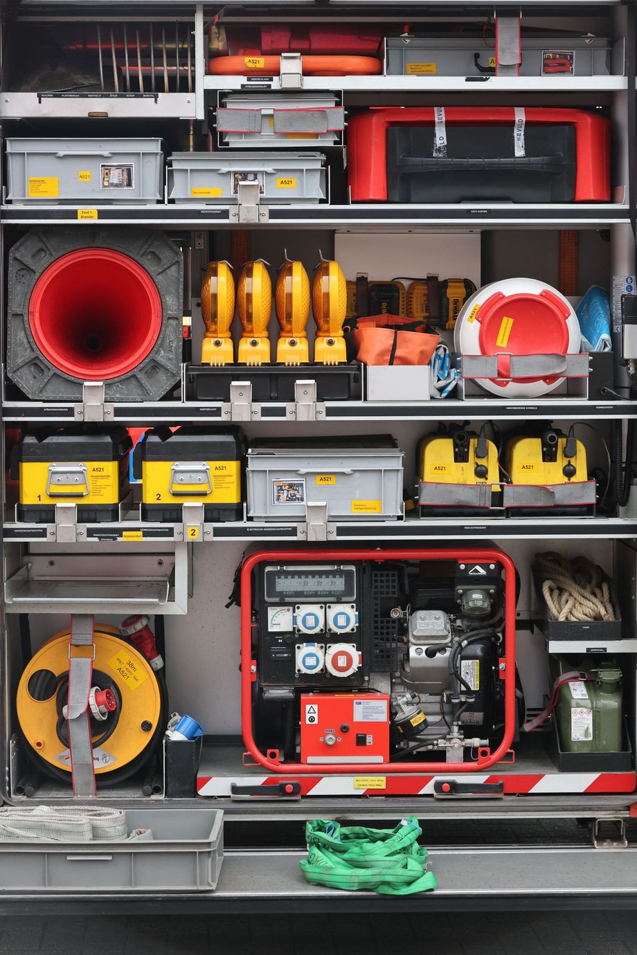 Open fire truck compartments filled with rescue tools, hoses, lights, and generators