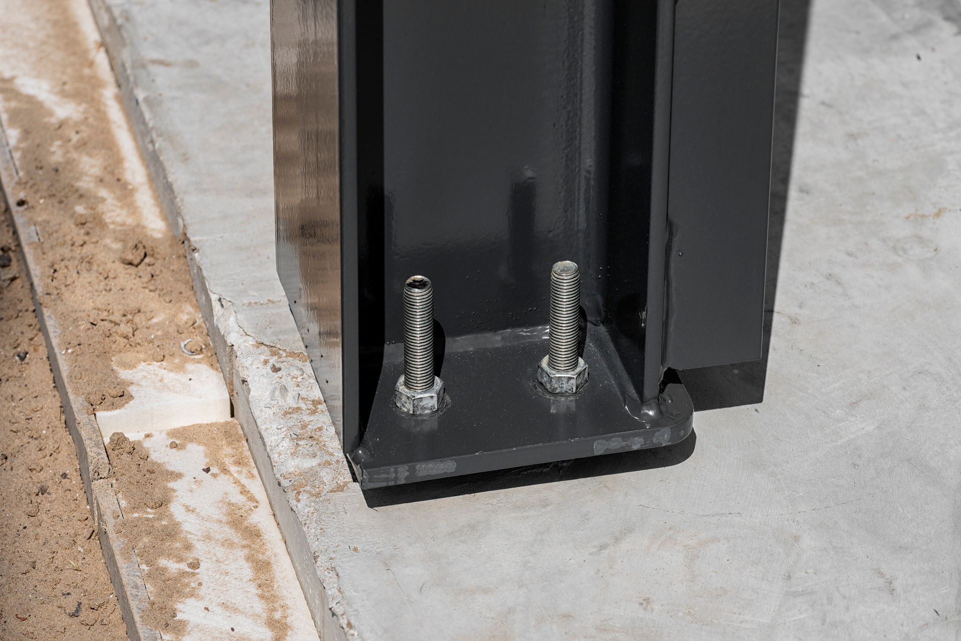 Foundation metal beam bracing with steel nuts and bolts attached to a steel beam for support.