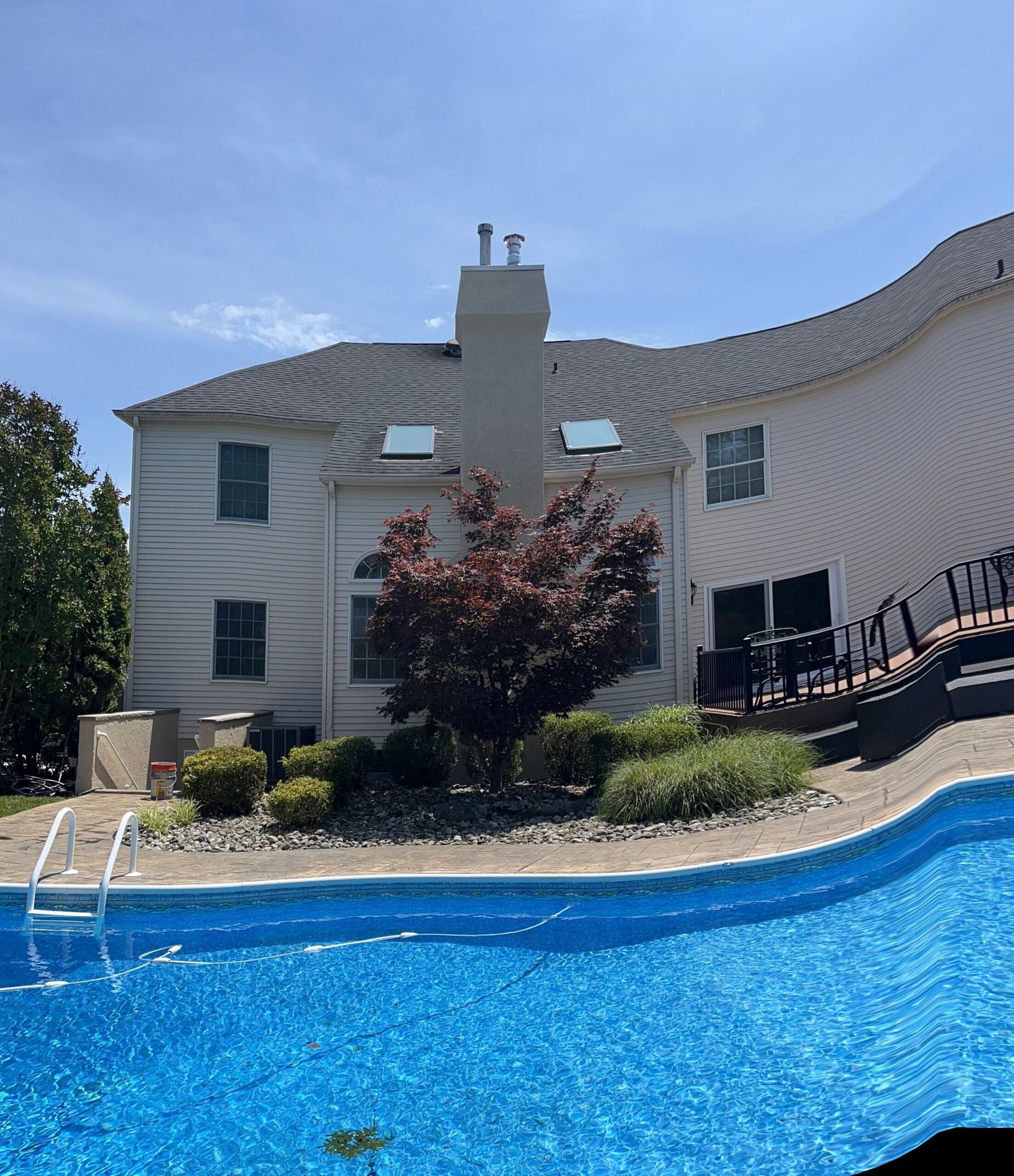 House with a swimming pool and patio under a clear blue sky